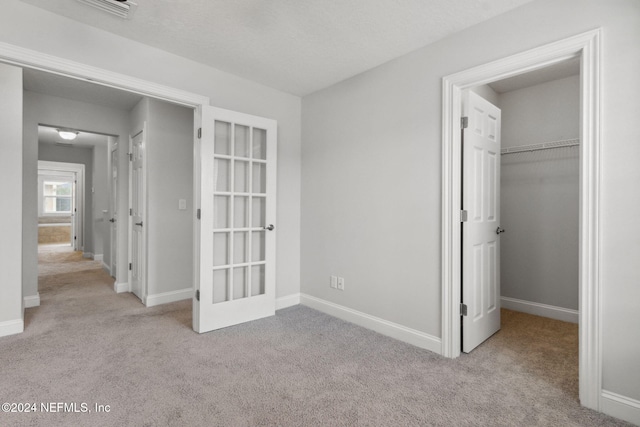 unfurnished bedroom with light carpet and a closet