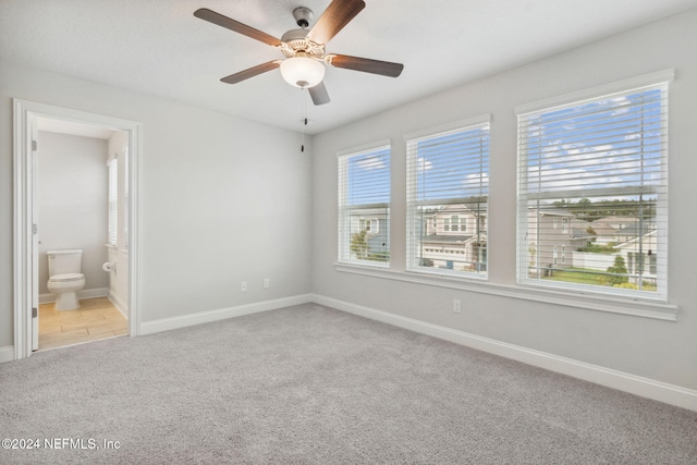 carpeted empty room with a healthy amount of sunlight and ceiling fan