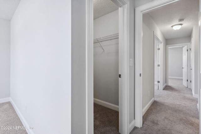 interior space featuring a textured ceiling and light carpet