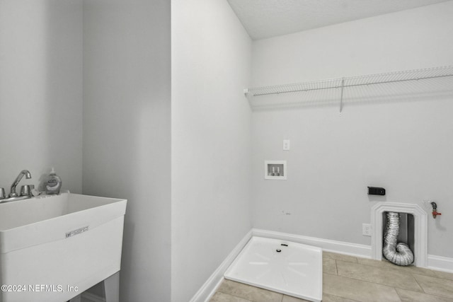 laundry room featuring gas dryer hookup, hookup for a washing machine, sink, and light tile patterned flooring