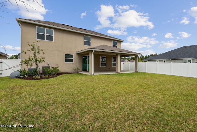 rear view of property featuring a patio and a yard