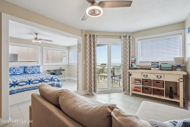 413 1st St S Unit 303, Jacksonville Beach, FL 32250 - tiled living room with ceiling fan and a textured ceiling