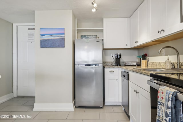 413 1st St S Unit 303, Jacksonville Beach, FL 32250 - kitchen featuring stainless steel appliances, white cabinetry, light tile patterned floors, stone counters, and sink