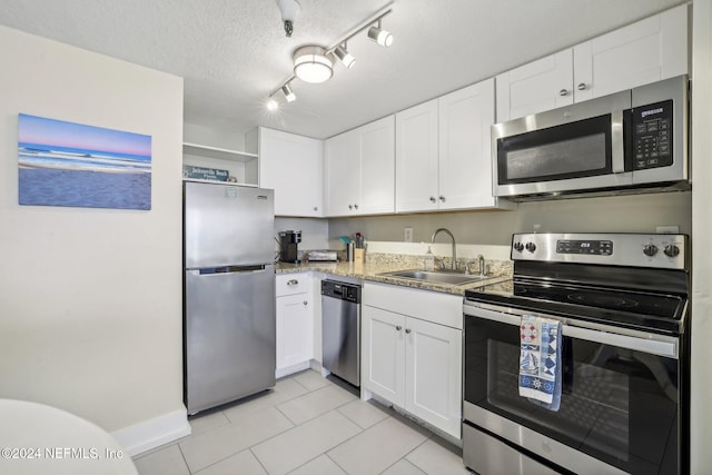 413 1st St S Unit 303, Jacksonville Beach, FL 32250 - kitchen featuring stainless steel appliances, white cabinetry, sink, track lighting, and a textured ceiling