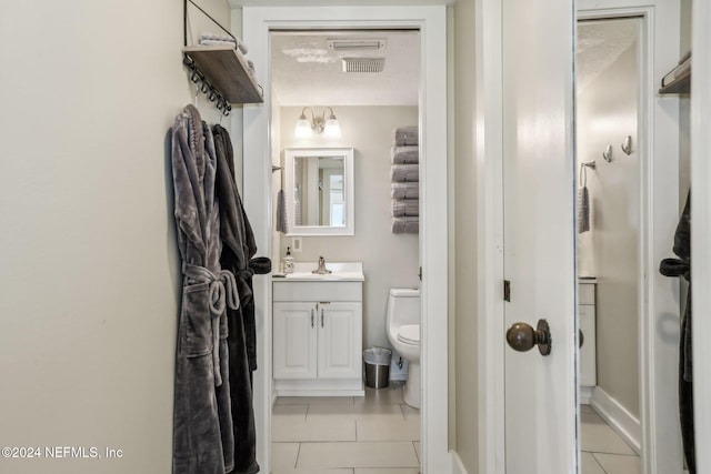 413 1st St S Unit 303, Jacksonville Beach, FL 32250 - bathroom with toilet, vanity, a textured ceiling, and tile patterned flooring