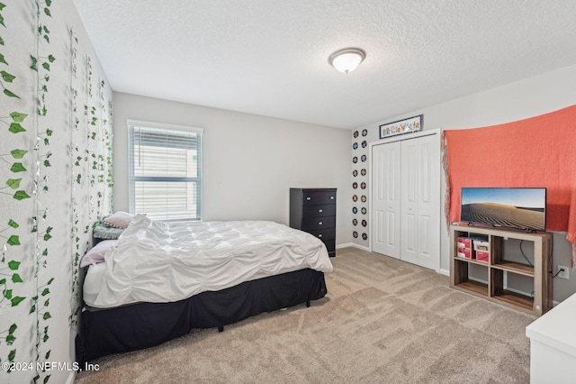 bedroom featuring a closet, a textured ceiling, and carpet floors