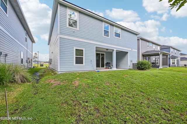 back of house featuring a lawn and a patio