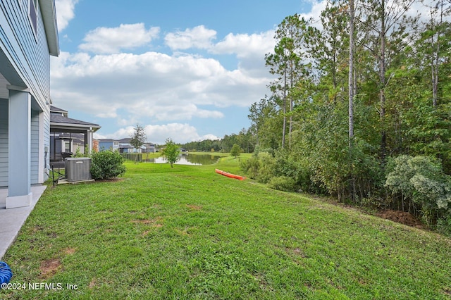 view of yard featuring central AC unit and a water view