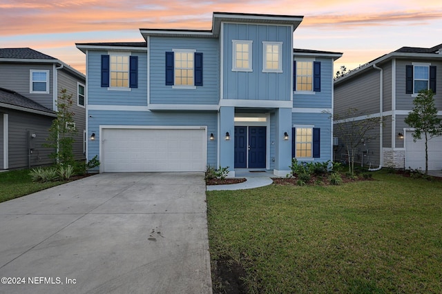 front facade with a garage and a lawn