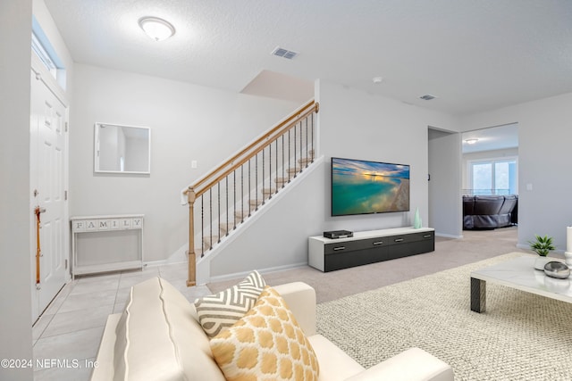 living room featuring a textured ceiling and light carpet