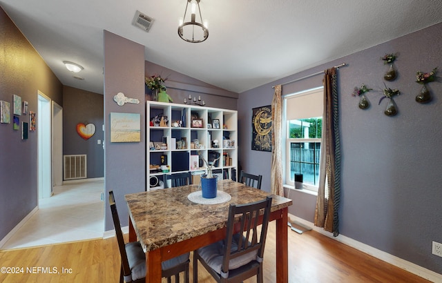 dining room featuring light wood-type flooring and lofted ceiling