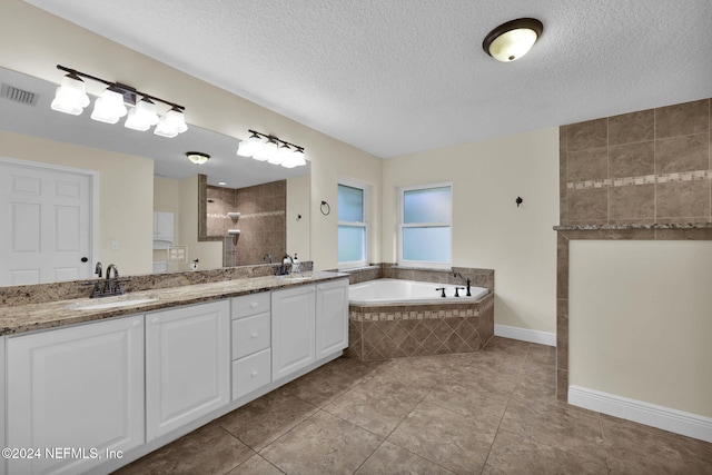 bathroom featuring shower with separate bathtub, tile patterned floors, a textured ceiling, and vanity