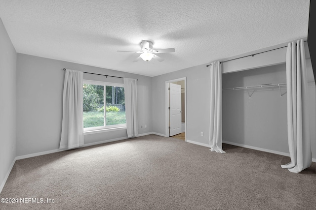 unfurnished bedroom with ceiling fan, carpet floors, a closet, and a textured ceiling