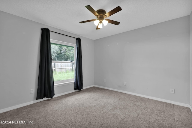 carpeted empty room with ceiling fan and a textured ceiling