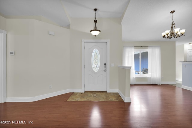 entryway featuring lofted ceiling, hardwood / wood-style floors, and a chandelier