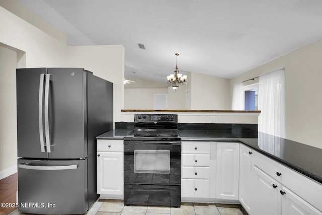 kitchen featuring vaulted ceiling, stainless steel refrigerator, white cabinetry, kitchen peninsula, and black range with electric stovetop