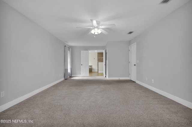 carpeted spare room with ceiling fan and a textured ceiling