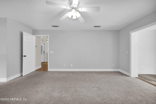 empty room with ceiling fan, carpet floors, and a textured ceiling