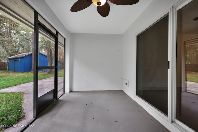 unfurnished sunroom with ceiling fan