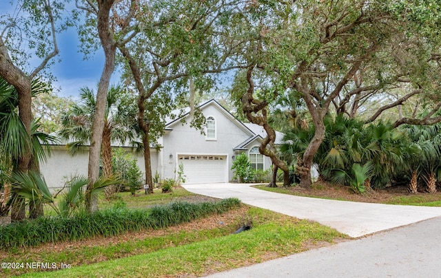 traditional-style home featuring driveway, stucco siding, and an attached garage