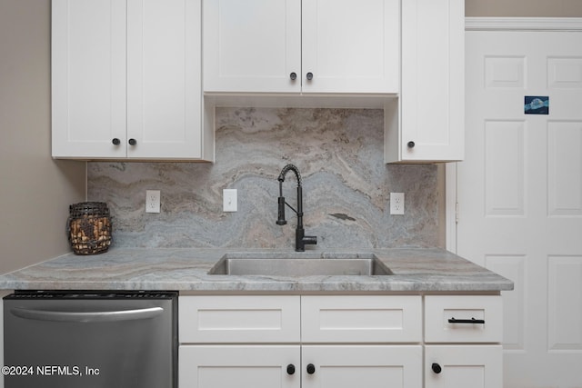 kitchen featuring stainless steel dishwasher, decorative backsplash, white cabinetry, and sink