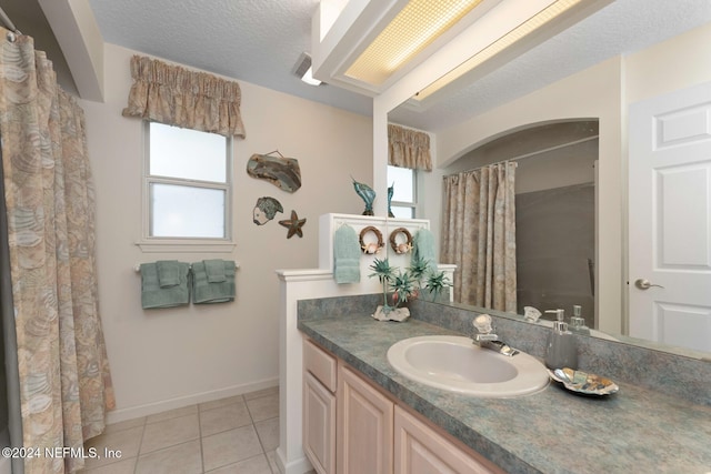 bathroom featuring tile patterned flooring, vanity, and a textured ceiling