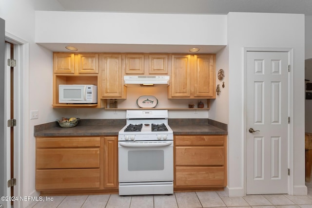 408 Third St, Saint Augustine, FL 32084 - kitchen with white appliances, under cabinet range hood, dark countertops, light tile patterned floors, and light brown cabinets