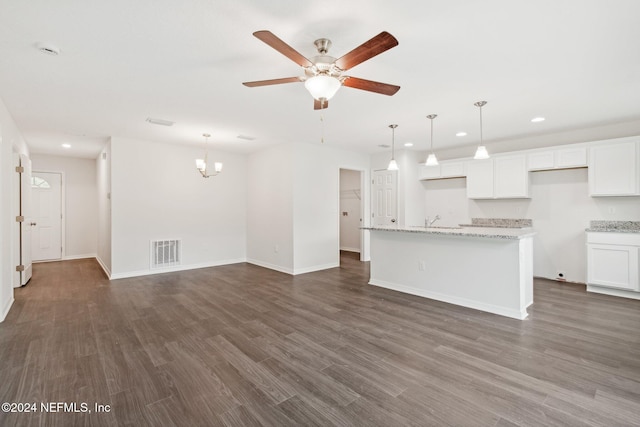 unfurnished living room with ceiling fan with notable chandelier and dark hardwood / wood-style floors