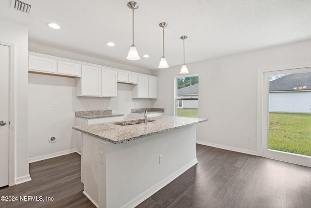 kitchen featuring white cabinetry, light stone countertops, sink, and a center island with sink