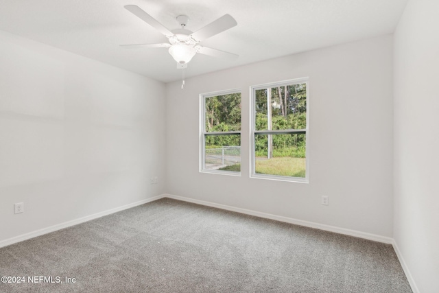 carpeted spare room with ceiling fan