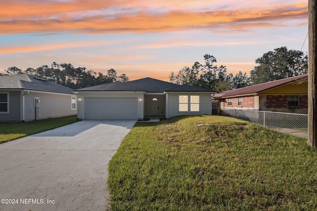 ranch-style home with a garage and a lawn