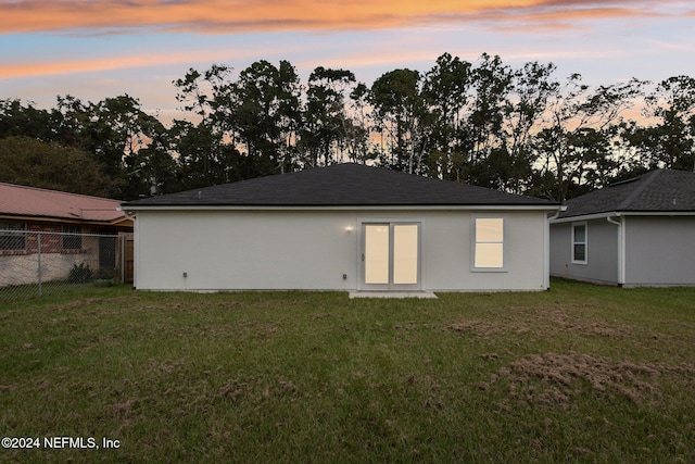 back house at dusk with a yard