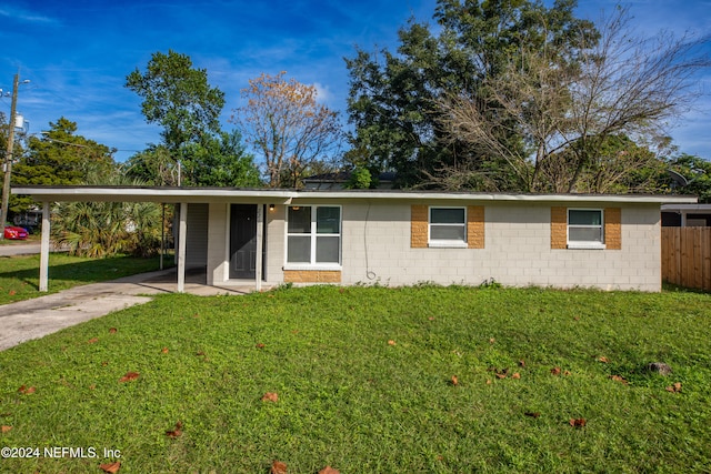 ranch-style home featuring a front lawn and a carport