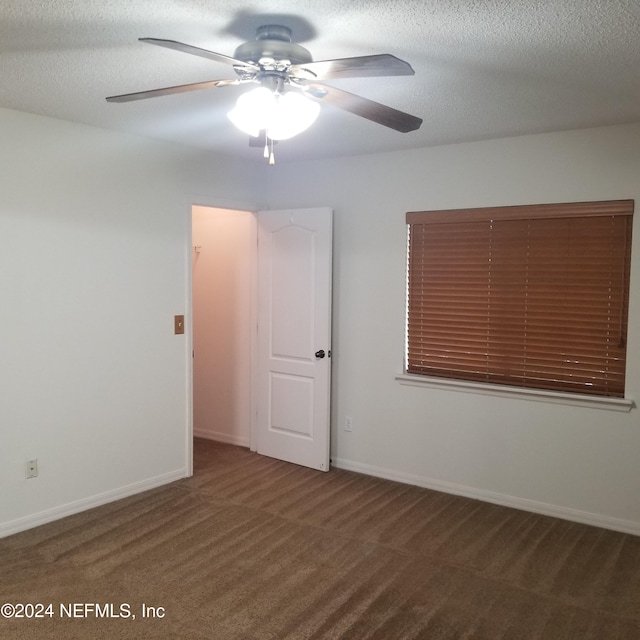 carpeted spare room with ceiling fan and a textured ceiling