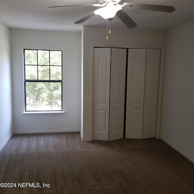 unfurnished bedroom with ceiling fan, a textured ceiling, a closet, and carpet flooring