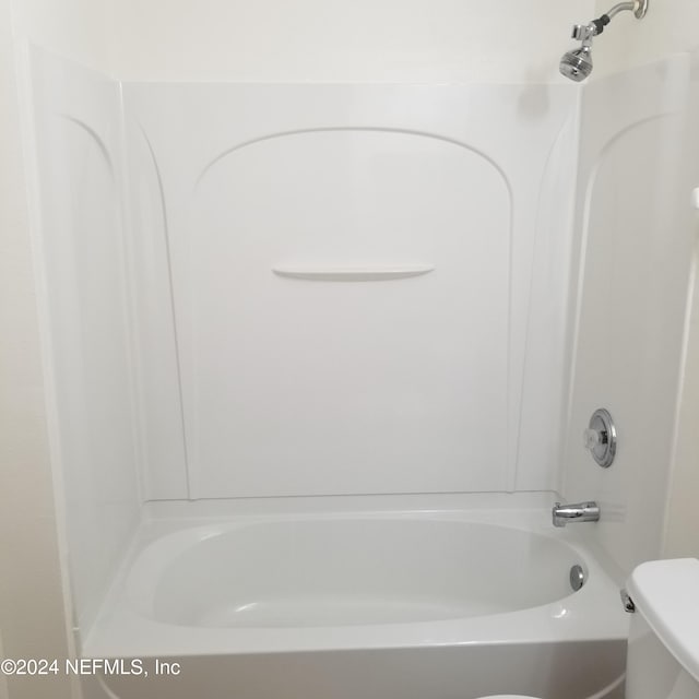 bathroom with toilet and washtub / shower combination