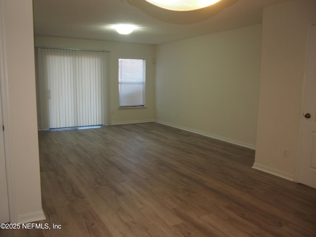 unfurnished room with dark wood-type flooring