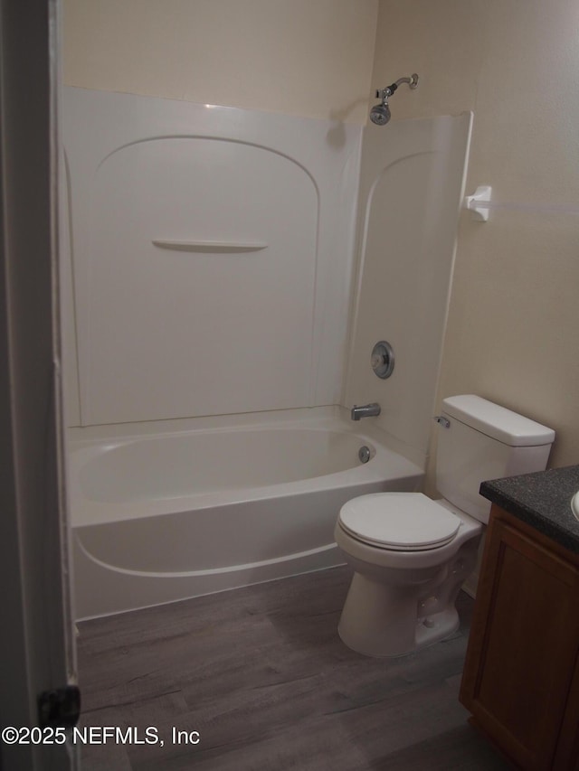 full bathroom with toilet, vanity, wood-type flooring, and bathing tub / shower combination