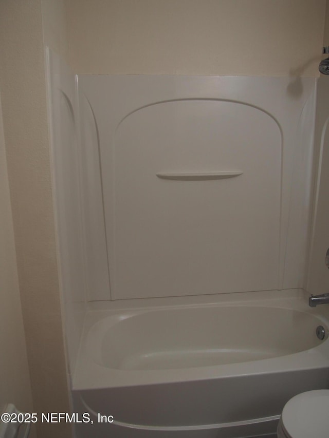 bathroom with toilet and washtub / shower combination