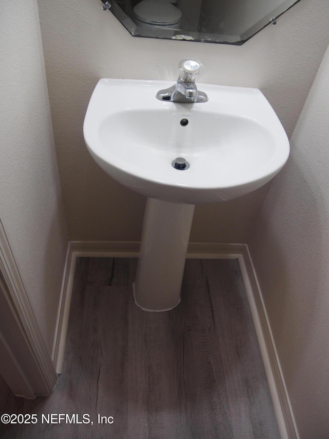 bathroom featuring toilet and wood-type flooring