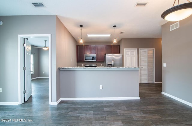 kitchen with hanging light fixtures, ceiling fan, light stone counters, and appliances with stainless steel finishes