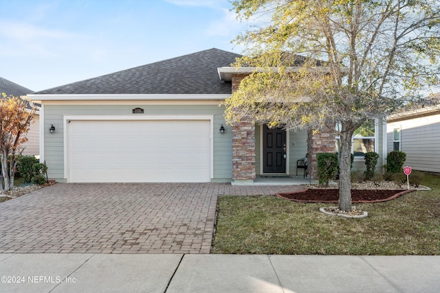 view of front of home with a front yard and a garage