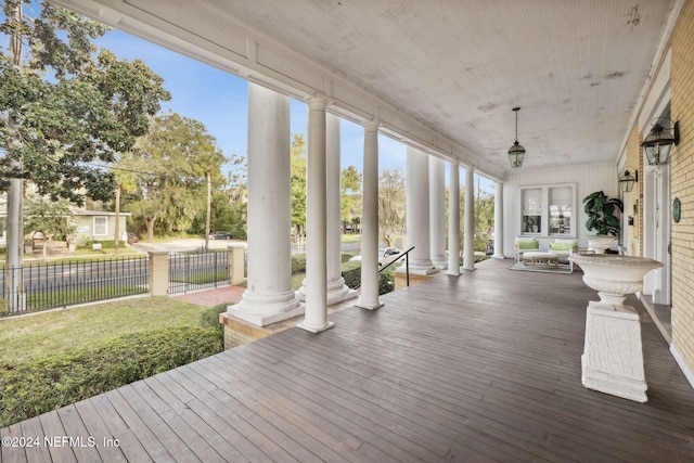 wooden terrace featuring a yard and covered porch