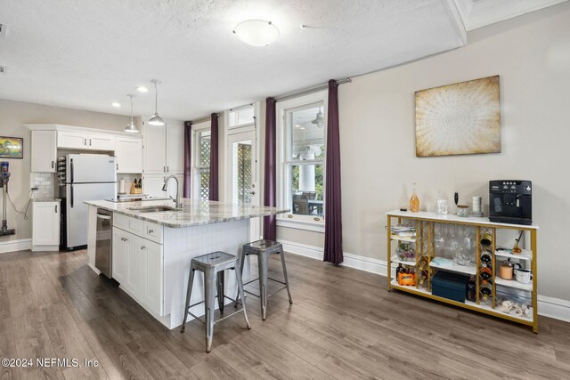 kitchen with a center island with sink, white cabinetry, appliances with stainless steel finishes, sink, and dark wood-type flooring