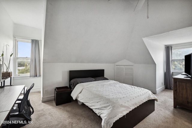 bedroom featuring light carpet and lofted ceiling