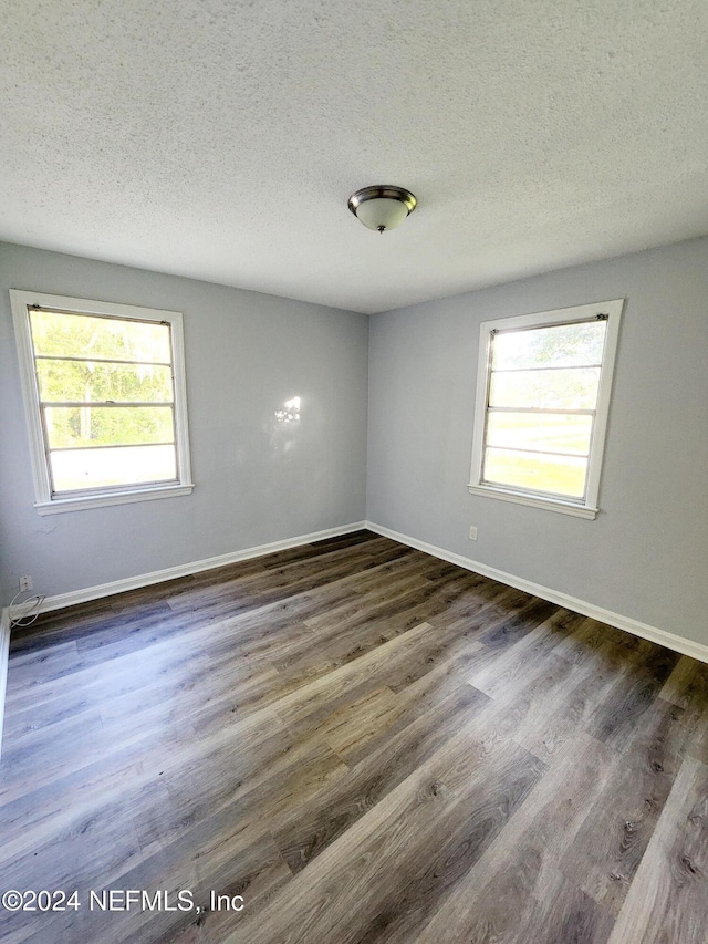 empty room featuring dark wood-type flooring and a textured ceiling