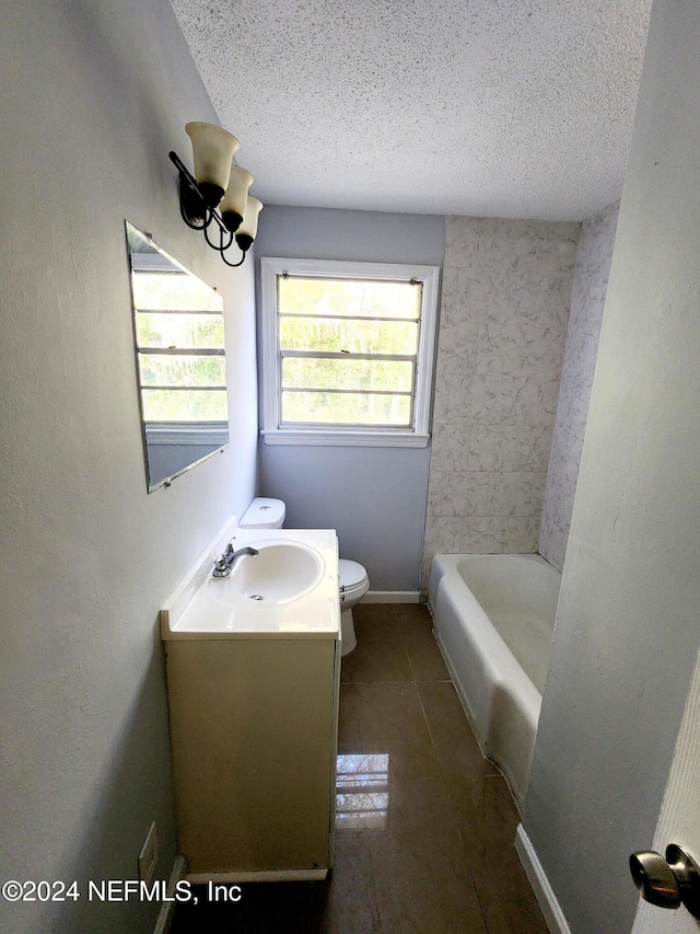 bathroom featuring tile patterned flooring, vanity, toilet, and a textured ceiling