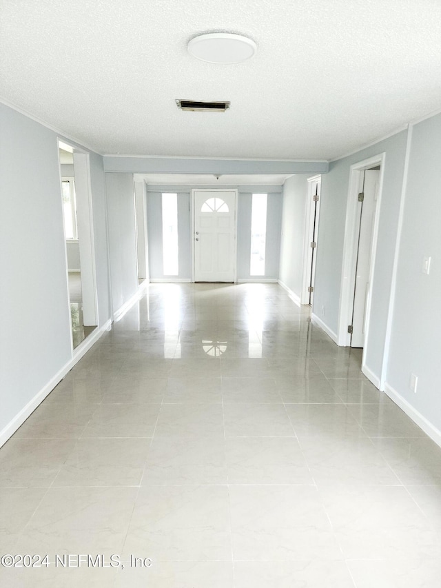 interior space with light tile patterned flooring and a textured ceiling