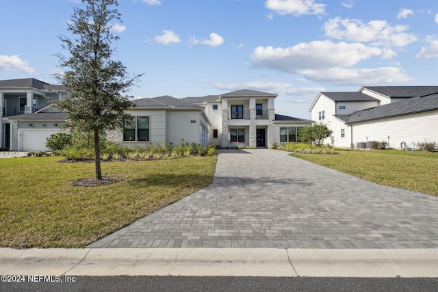 view of front facade featuring a balcony and a front lawn