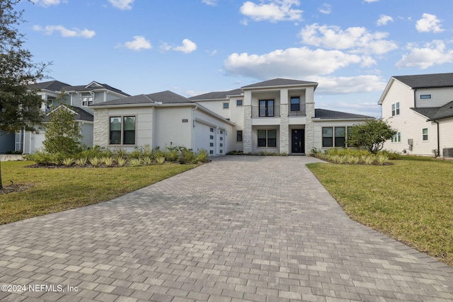 view of front of house featuring a balcony and a front yard